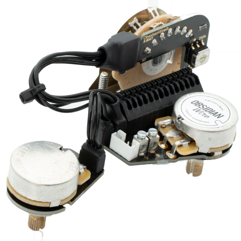 A Stratocaster solderless wiring harness with black wiring, silver metal potentiometers, and a white ObidianWire sticker, isolated on a white background.