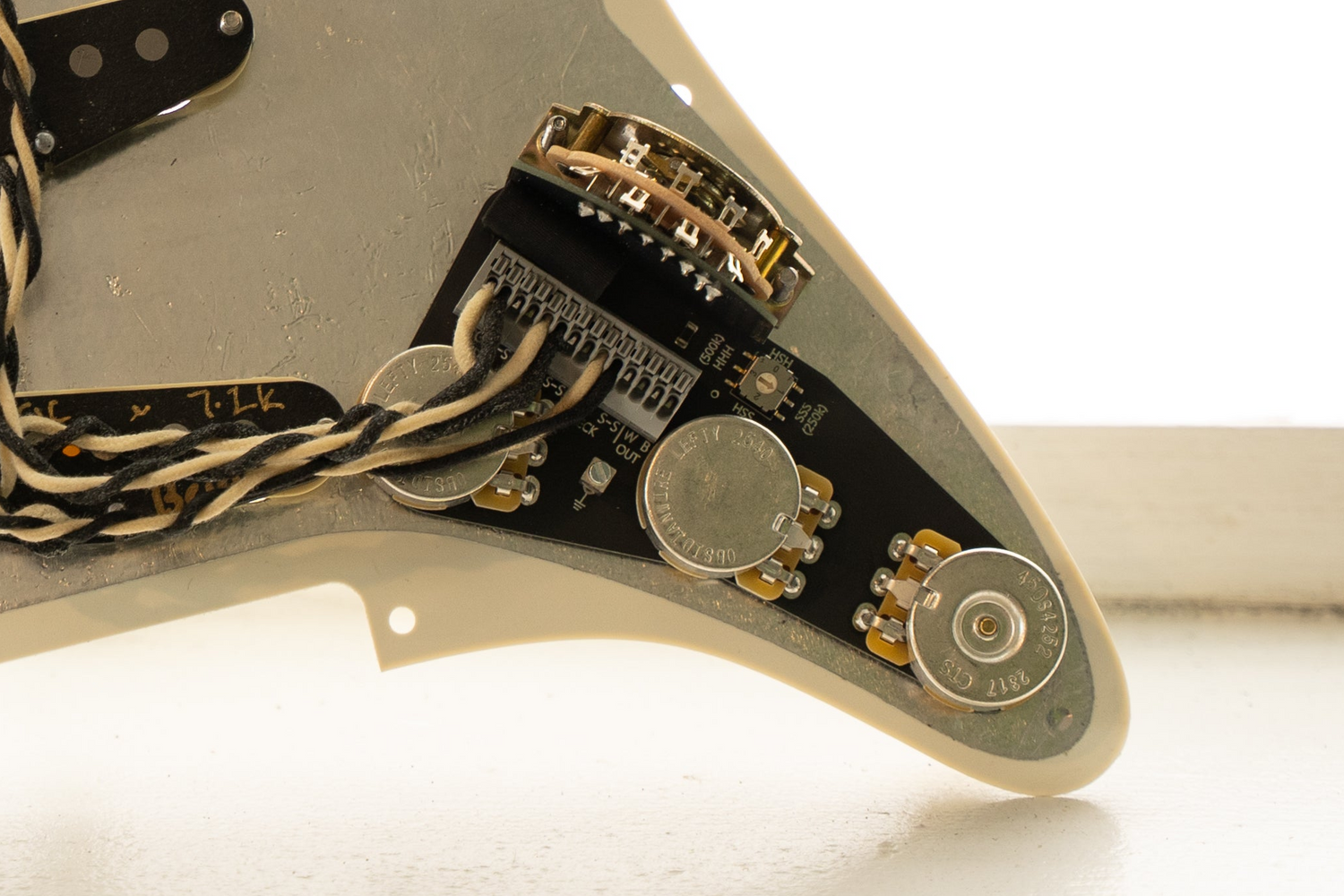 Left handed blender wiring harness for Stratocaster, shown with pickup wires installed, and mounted on a shielded pickguard. The background is light.